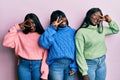 Three young african american friends wearing wool winter sweater doing peace symbol with fingers over face, smiling cheerful Royalty Free Stock Photo