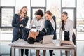 Three young angry businesswomen punishing businessman lying on table