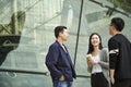 Three young asian adults standing talking on street Royalty Free Stock Photo
