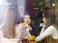 Three young asian women chatting talking in coffee shop Royalty Free Stock Photo