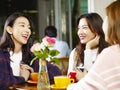 Three young asian women chatting talking in coffee shop