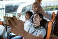 three young Asians smile and pose to their cellphone camera while taking a selfie together