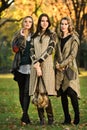 Three young beautiful fashion models posing in the park. Royalty Free Stock Photo