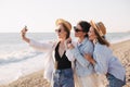 Three young beautiful happy women female friends making selfie and having fun on a beach Royalty Free Stock Photo