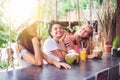 Three young beautiful slender girlfriends drink necks and coconuts in a stylish beach bar Royalty Free Stock Photo