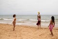 Three young and beautiful women playing boley on the shore of the beach. The women are enjoying the game and their day at the Royalty Free Stock Photo