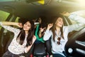 Three young beauty girls driving in a car dancing and having fun in city street Royalty Free Stock Photo