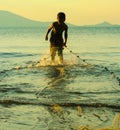 Child Worker, with fishing net pulling in the days catch,