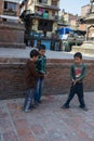 Three young boys playing a game with a coin in the street, Kathmandu, Nepal, March 2014 Royalty Free Stock Photo