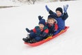 Three young boys sledding downhill together Royalty Free Stock Photo