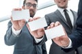 Three young business partners showing their business cards. Royalty Free Stock Photo