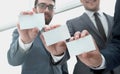 Three young business partners showing their business cards. Royalty Free Stock Photo