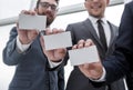 Three young business partners showing their business cards. Royalty Free Stock Photo