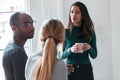 Three young business people drinking coffee while taking a break in the office Royalty Free Stock Photo