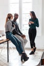 Three young business people drinking coffee while taking a break in the office Royalty Free Stock Photo