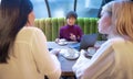 Three young business women sitting at table with laptop and working on a project in cafe. Teamwork, business meeting Royalty Free Stock Photo