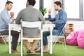 Three young businessmen sitting at table and working on new project together Royalty Free Stock Photo