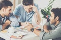 Three young businessmen sitting at table and working on new project together business Royalty Free Stock Photo