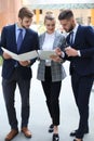 Three young businessmen standing discussing business at an office meeting