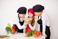 Three young chefs evaluate a salad isolated