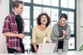 Three young colleagues laughing in the meeting room