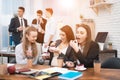 Three young cute girls eating sweet cake at lunchtime in office. Lunch break. Royalty Free Stock Photo