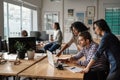 Three young designers using a laptop together at work Royalty Free Stock Photo