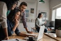 Three young designers working on a laptop in an office Royalty Free Stock Photo