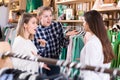 Three young emotional women friends talking in clothes shop Royalty Free Stock Photo