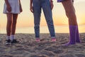 three young female friends standing on the beach and looking at the sea on sunrise. Royalty Free Stock Photo