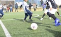 Three young football players. Children play a soccer game. Legs in action with a ball