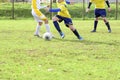 Three young football players. Children play a soccer game. Legs in action with a ball, dribbling