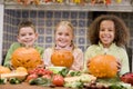 Three young friends on Halloween with pumpkins Royalty Free Stock Photo