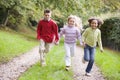 Three young friends running on a path outdoors
