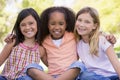 Three young girl friends sitting outdoors