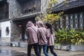 Three young girls in beige blouses walk through the scenic spot