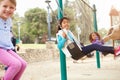 Three Young Girls Playing On Swing In Playground Royalty Free Stock Photo