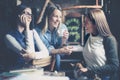 Three young girls sitting in cafe and having conversation.