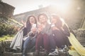 Three young girls sitting on the stairs at the public park. Royalty Free Stock Photo