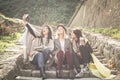 Three young girls sitting on the stairs at the public park. Three best friend making self picture in the public park. Girls Royalty Free Stock Photo