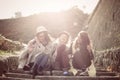 Three young girls sitting on the stairs at the public park. Royalty Free Stock Photo