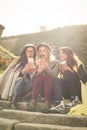 Three young girls sitting on the stairs at the public park. Royalty Free Stock Photo