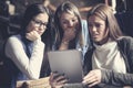 Three young girls together at home watching something o