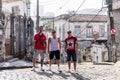 Three male tourists standing on an urban street in the Lapa neighbourhood of Rio de Janeiro surrounded by derelict buildings