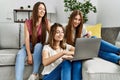 Three young hispanic woman smiling happy using laptop and credit card sitting on the sofa at home Royalty Free Stock Photo