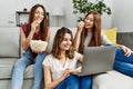 Three young hispanic woman smiling happy watching film using laptop at home Royalty Free Stock Photo