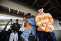 Three young intercultural hip hop dancers in casualwear standing by car Royalty Free Stock Photo