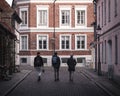 Three young male studens walking away from the camera in the old town of university city Lund, Sweden