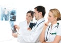 Three young medical workers examining x-rays Royalty Free Stock Photo