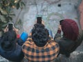 Three young men look down at their phones Royalty Free Stock Photo